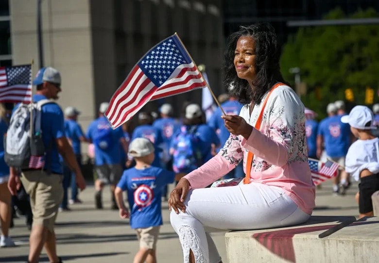 Woman holding an American flag at the Pittsburgh Labor Day Parade