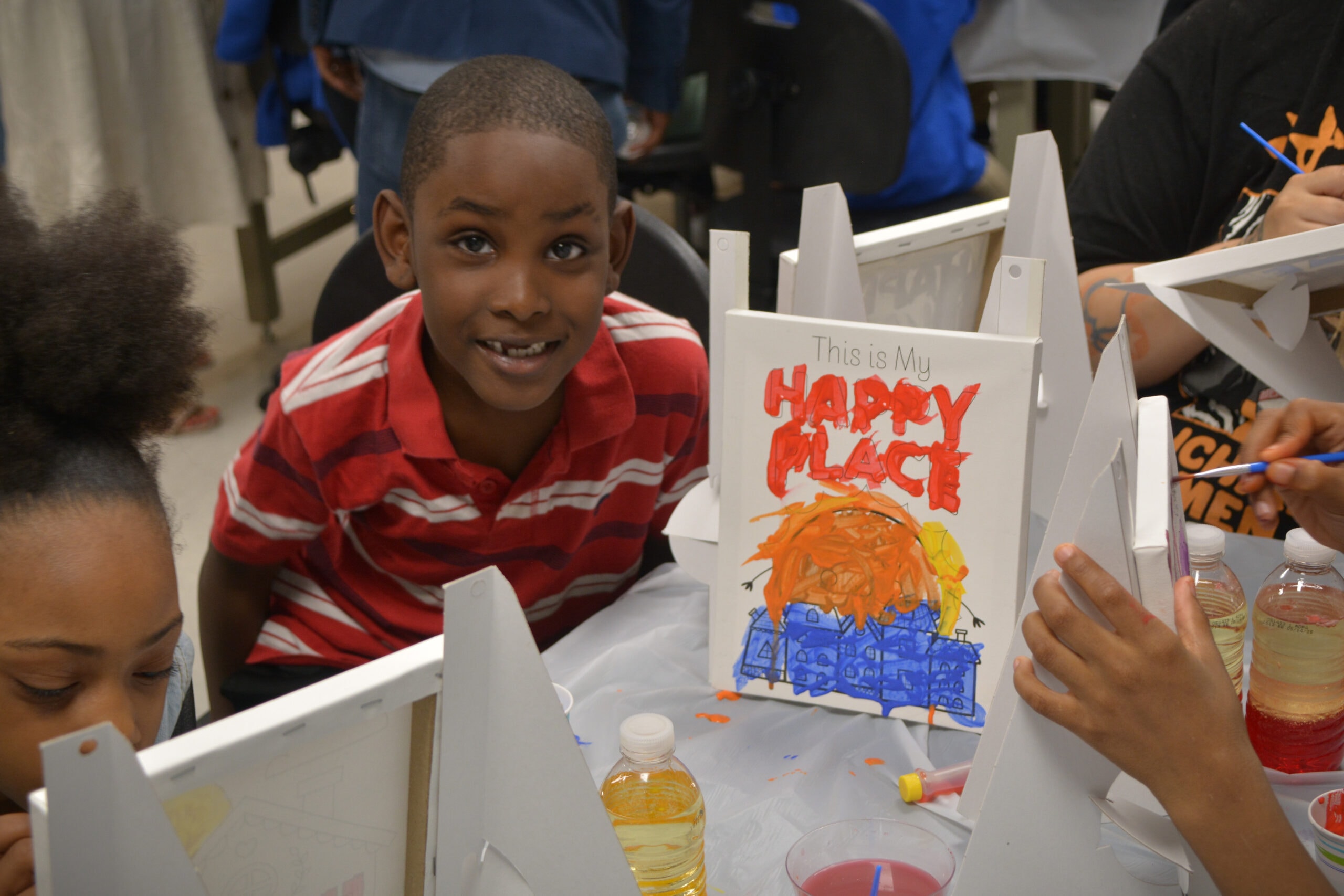 Child showing his Happy Place painting at Homewood Children's Village