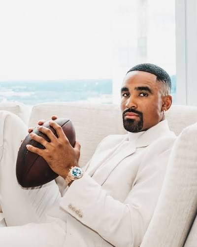 Jalen Hurts Eagles QB — white suit portrait with football