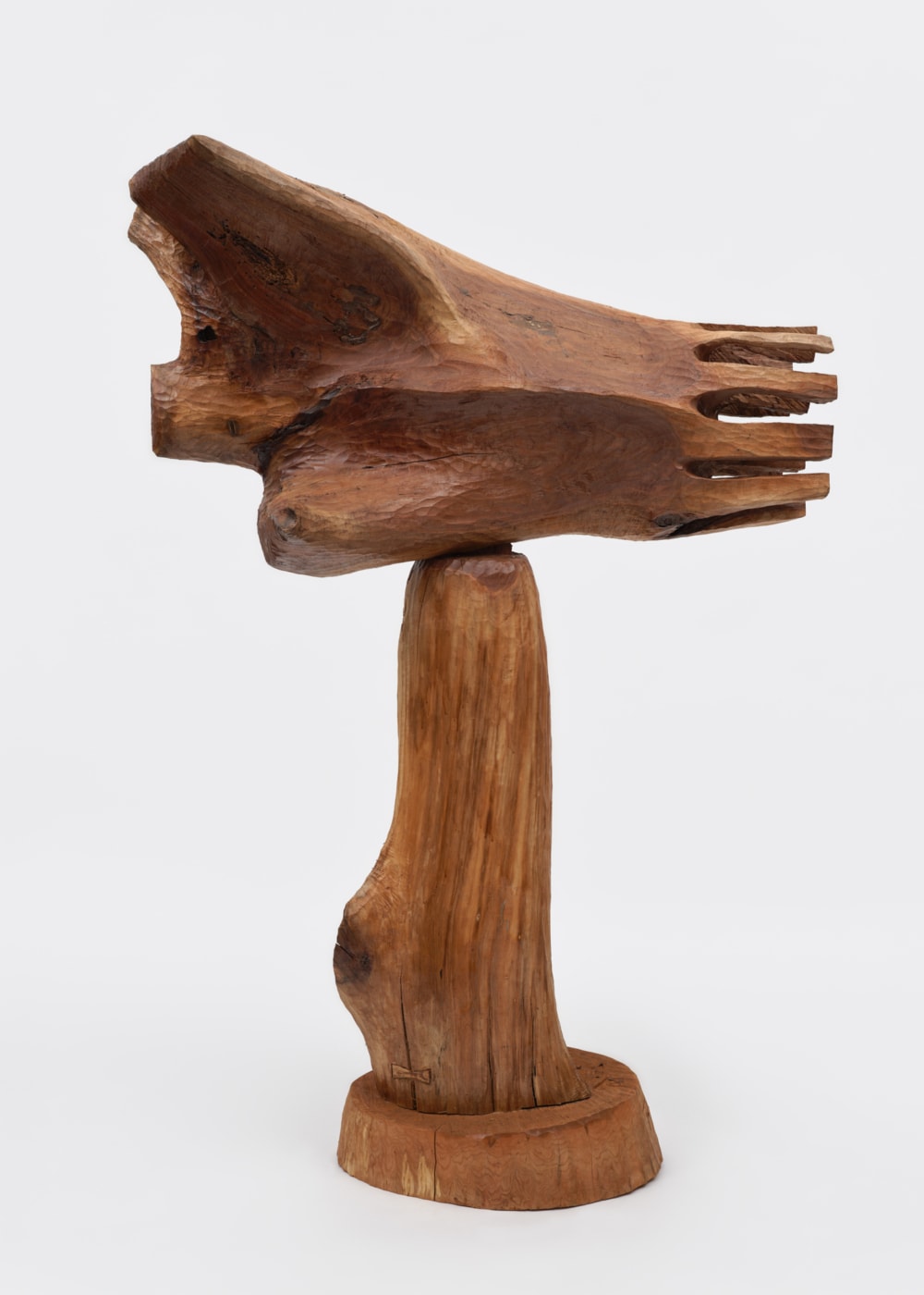 A Thaddeus Mosley wooden sculpture — carved hand form on a pedestal